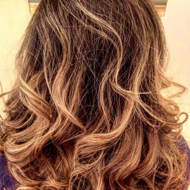 Lived-in caramel balayage through brunette waves by Hair By Konstantinos in Toorak